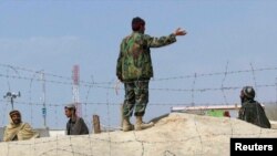 چمن سرحد پر نصب باڑ کے قریب ایک افغان فوجی لوگوں کے باڑ کے قریب جانے سے روک رہا ہے۔ فائل فوٹو