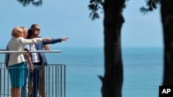 На архівному фото президент Росії Володимир Путін (другий зліва) у дитячому санаторії "Артек" в Гурзуфі, Крим, 24 червня 2017 року. Ліворуч - віце-прем'єр Ольга Голодець, другий справа - тодішній директор дитячого санаторію "Артек" Олексій Каспржак. (Sputnik/AP)