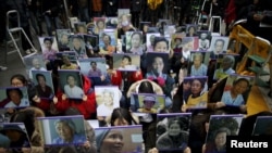 FILE - Students hold portraits of deceased former South Korean "comfort women" during a rally in front of Japanese embassy in Seoul, South Korea, December 30, 2015.