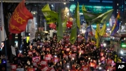 FILE - Protesters march to the presidential office after a candlelight vigil against South Korean President Yoon Suk Yeol in Seoul, South Korea, Dec. 5, 2024.