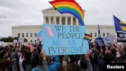 FILE - LGBTQ activists and supporters hold a rally outside the U.S. Supreme Court as it hears arguments in a major LGBTQ rights case in Washington, Oct. 8, 2019.
