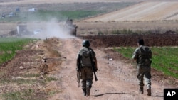 FILE - Turkish soldiers patrol near the border with Syria, outside the village of Elbeyli, east of the town of Kilis, southeastern Turkey, July 24, 2015.