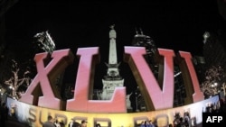 Người hâm mộ chụp hình kỷ niệm trước logo Super Bowl XLVI tại Indianapolis, 1/2/2012