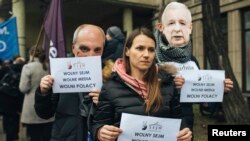 FILE - Demonstrators hold banners "Free Parliamnent, Free Media, Free Poles" during a protest in Gdansk, Poland, Dec. 17, 2016.