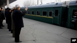 North Korean senior diplomat Kim Ki Nam, right, and others see off the Moranbong Band and the State Merited Chorus of North Korea leaving the station in Pyongyang, North Korea in Pyongyang, Wednesday, Dec. 9, 2015. 
