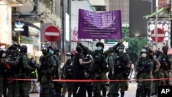 Police officers raise a warning banner at a downtown street in Hong Kong Sunday, Sept. 6, 2020. About 30 people were arrested Sunday at protests against the government's decision to postpone elections for Hong Kong's legislature, police and a news…