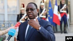 France's national cycling team trains as people wait to get a dose of the Pfizer-BioNTech COVID-19 vaccine at the indoor Velodrome National of Saint-Quentin-en-Yvelines in Montigny-le-Bretonneux, southwest of Paris, France.