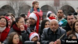 Warga menghadiri perayaan Natal di gereja Nativitas di kota Bethlehem, Tepi Barat, Palestina, Minggu (24/12). 