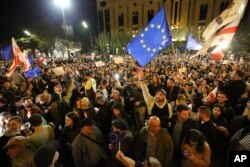 ARHIVA - Demonstranti mašu zastavama EU i Gruzije ispred zgrade parlamenta u Tbilisju, 15. aprila 2024. (Foto: AP/Zurab Tsertsvadze)