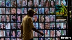 Лице поминува покрај сликите на заложниците киднапирани за време на смртоносниот напад на Хамас на 7 октомври, во Тел Авив